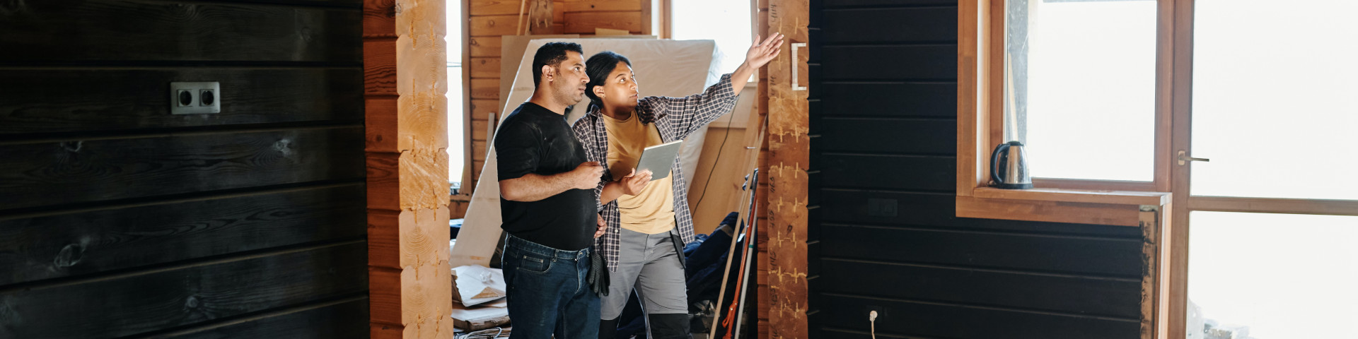 two individuals walking through residential construction site and reviewing work